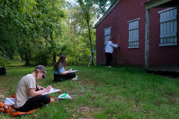 Students sketching and measuring a historic lockhouse