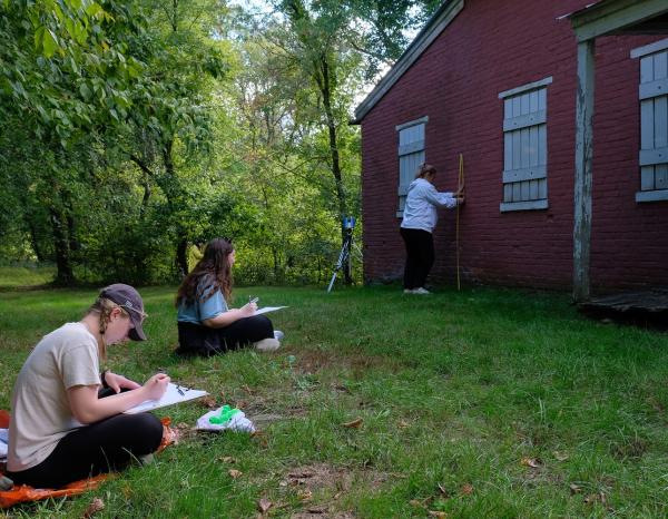Students sketching and measuring a historic lockhouse