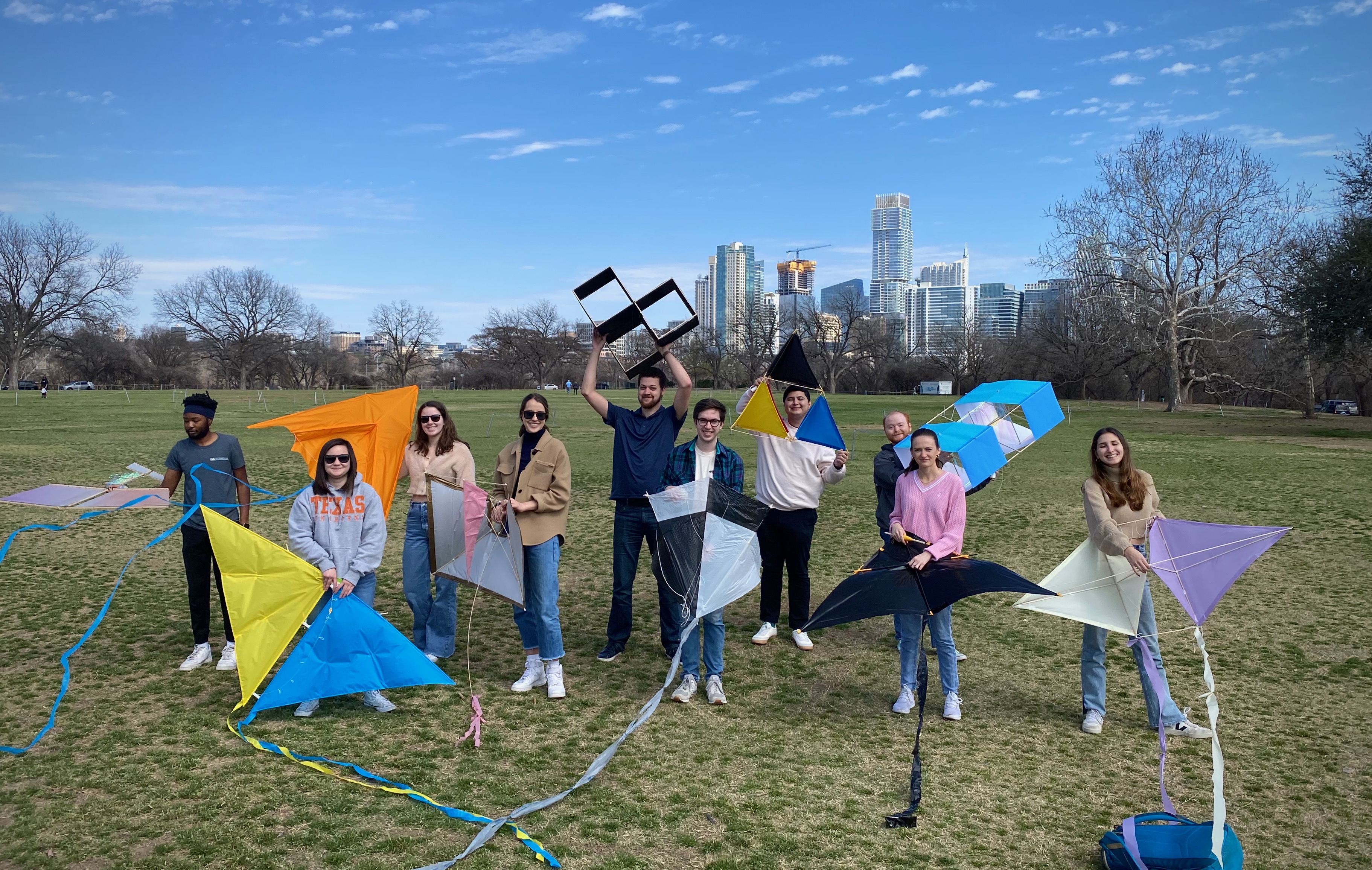 A group of students in Zilker Park with kites they made