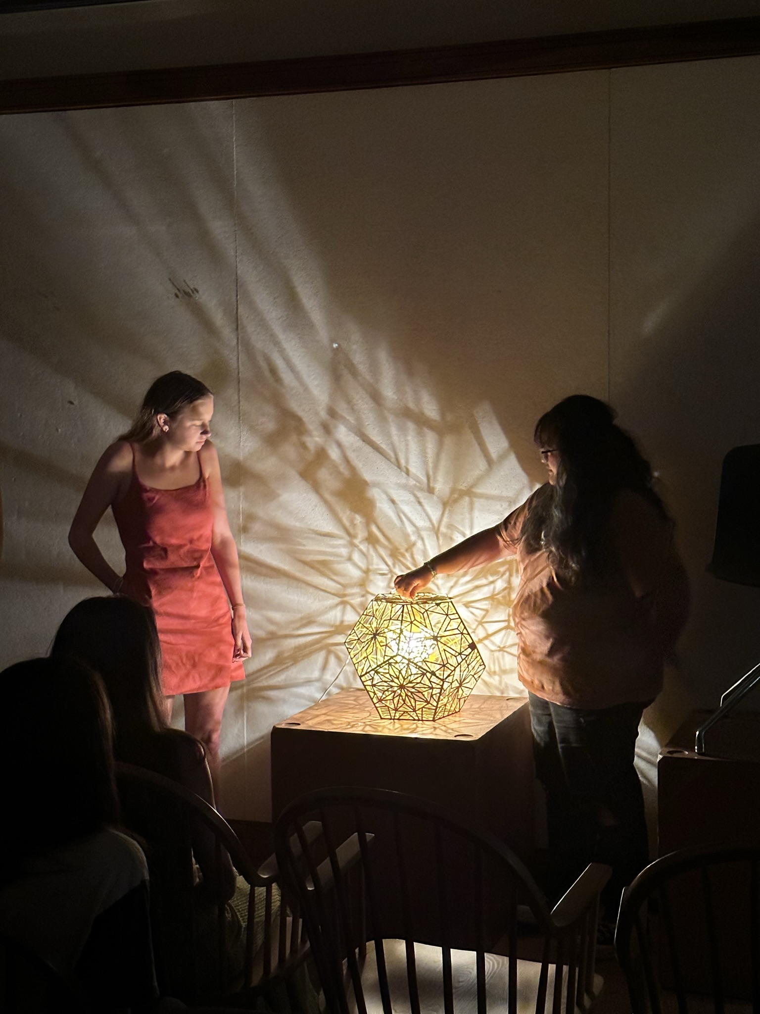 Students presenting their lamp, illuminated by the interplay of shadow and light