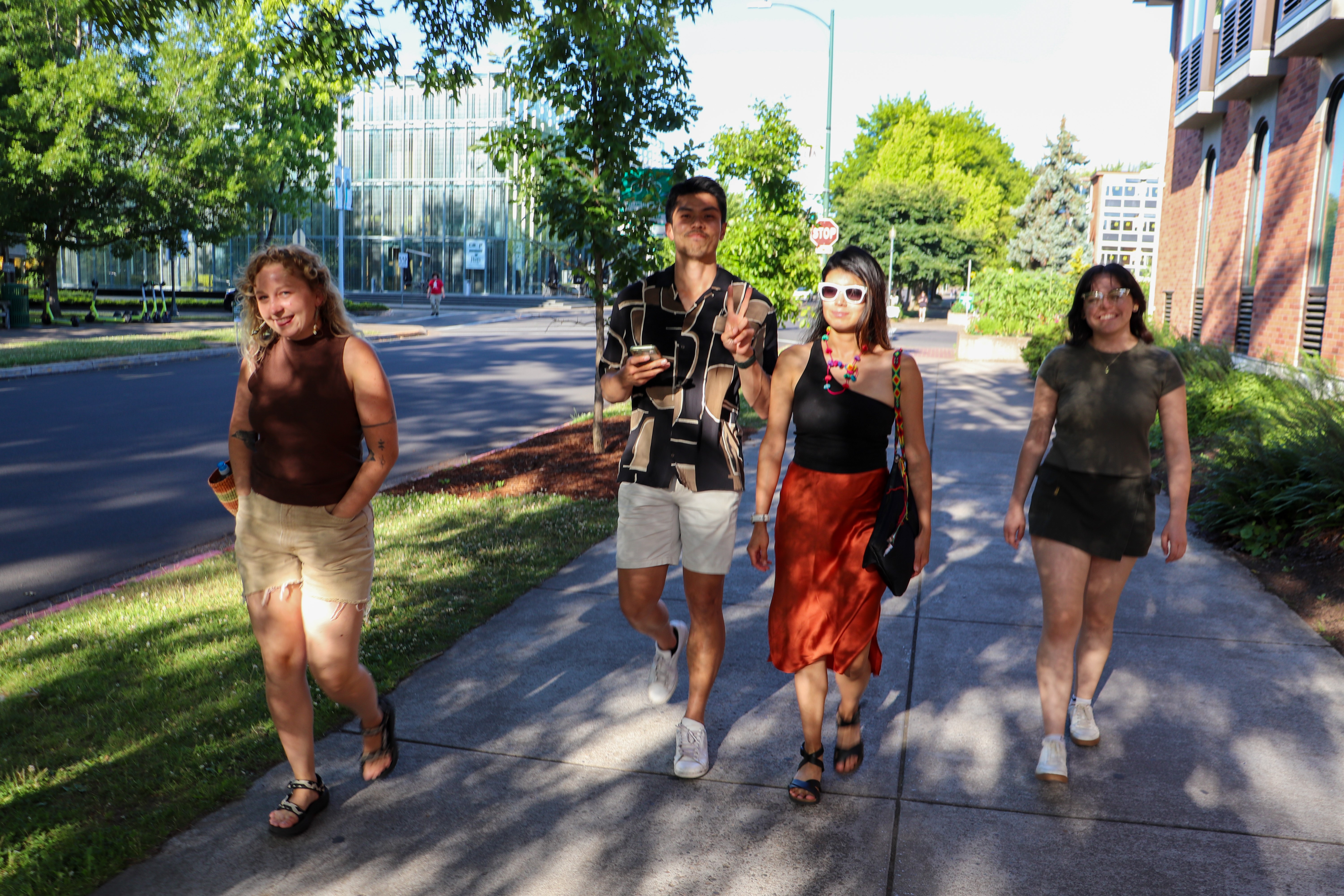 Design Futures student participants walking on a sidewalk, dappled in sunlight