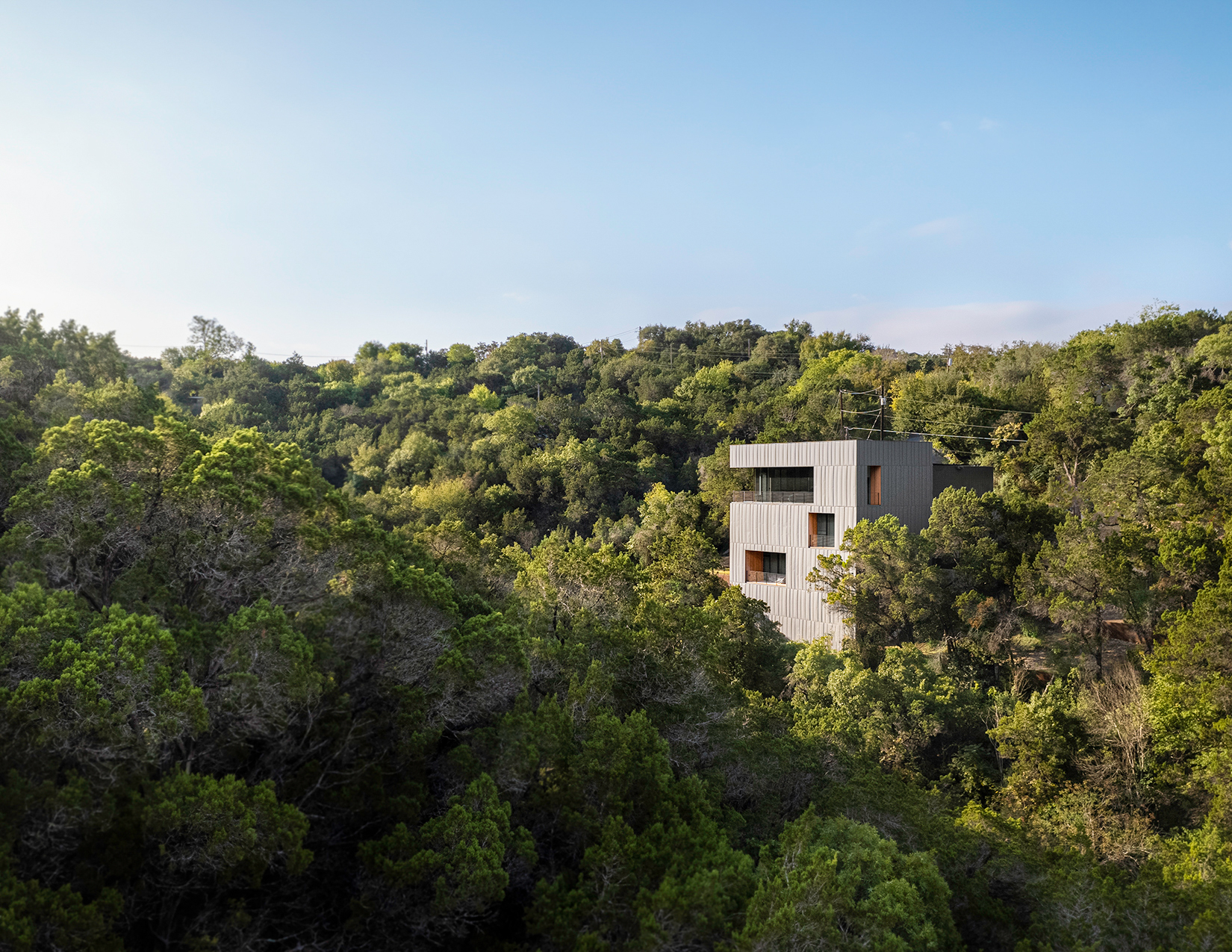 Wide angle shot of the Falcon Ridge Residence sitting amid a sea of trees