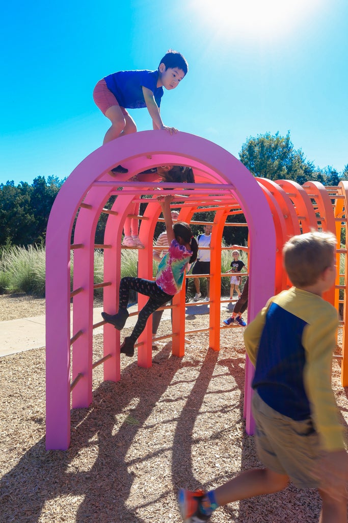 Children climbing on top of Monkey Bar Fort.