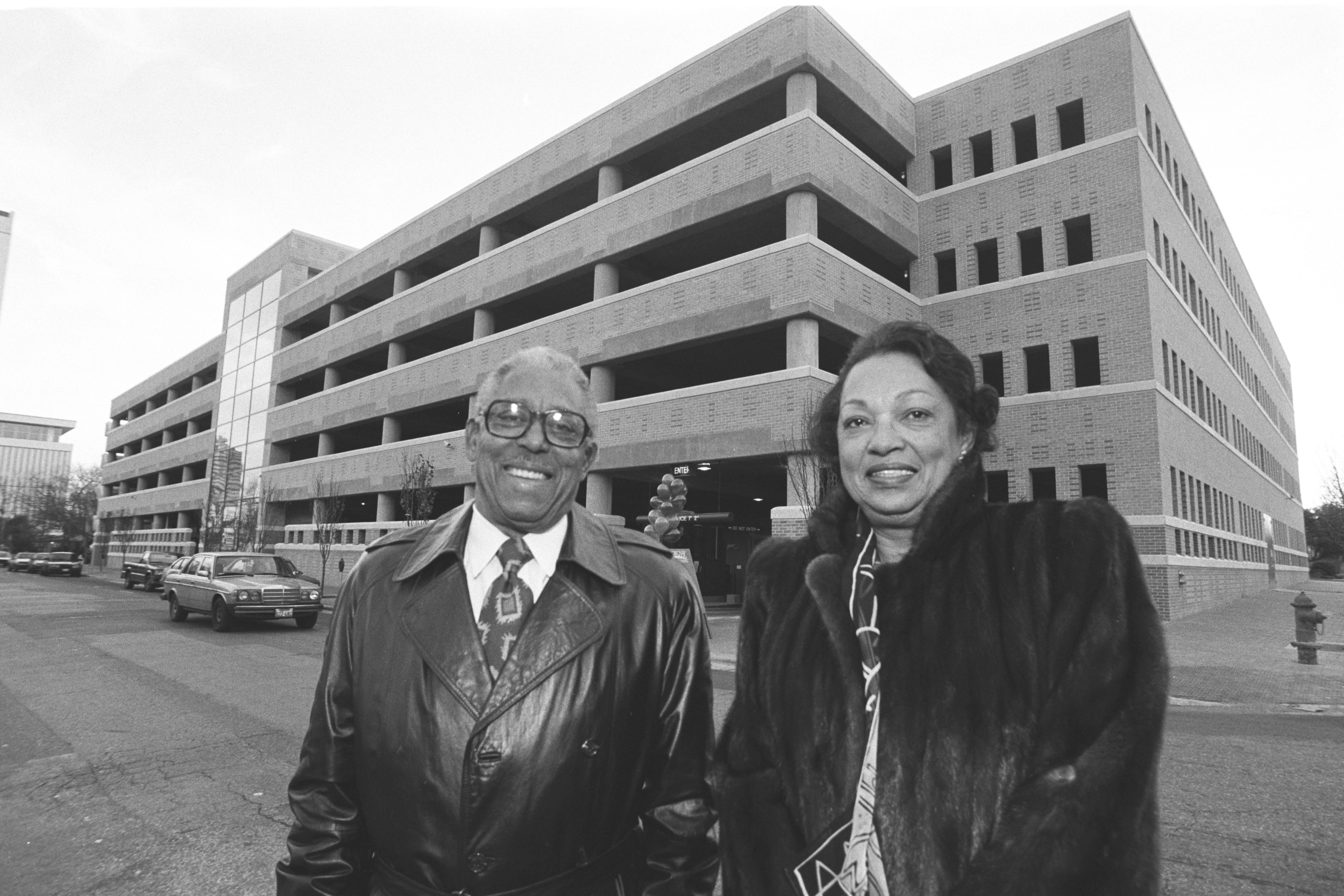 John Chase with his wife posing in front of the UT Austin San Antonio parking garage, which he designed.