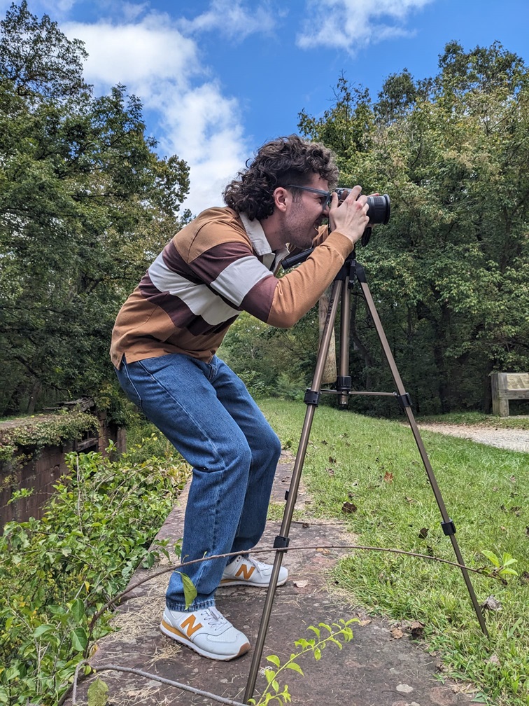 A student looking through a camera on a tripod