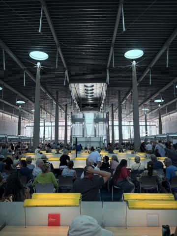 A photo of people in an industrial space with lights hanging from the ceiling