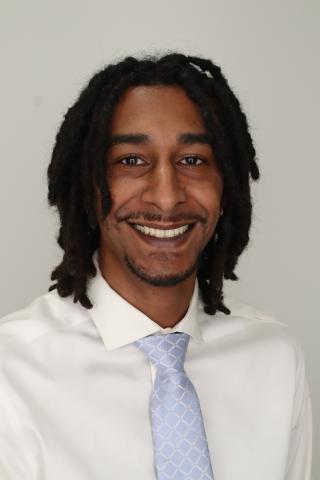 Gavin smiles at the camera for a headshot photo