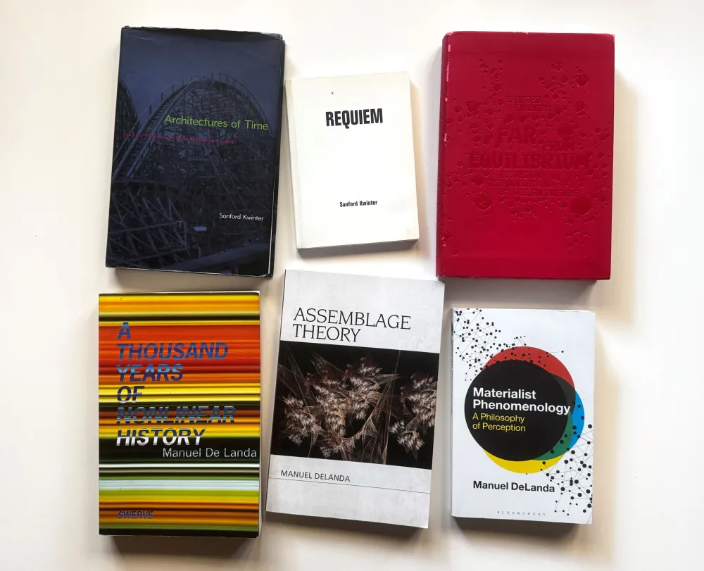 Several books of various colors laid out against a white background