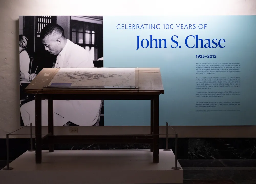 Photograph of exhibition title wall featuring John S. Chase's drafting table