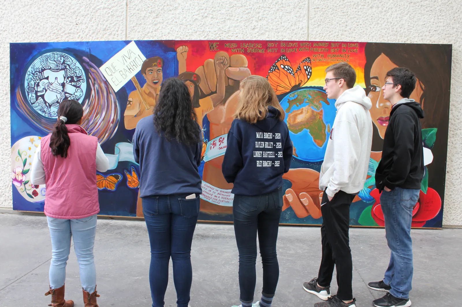 Backs of students seen looking at a colorful mural