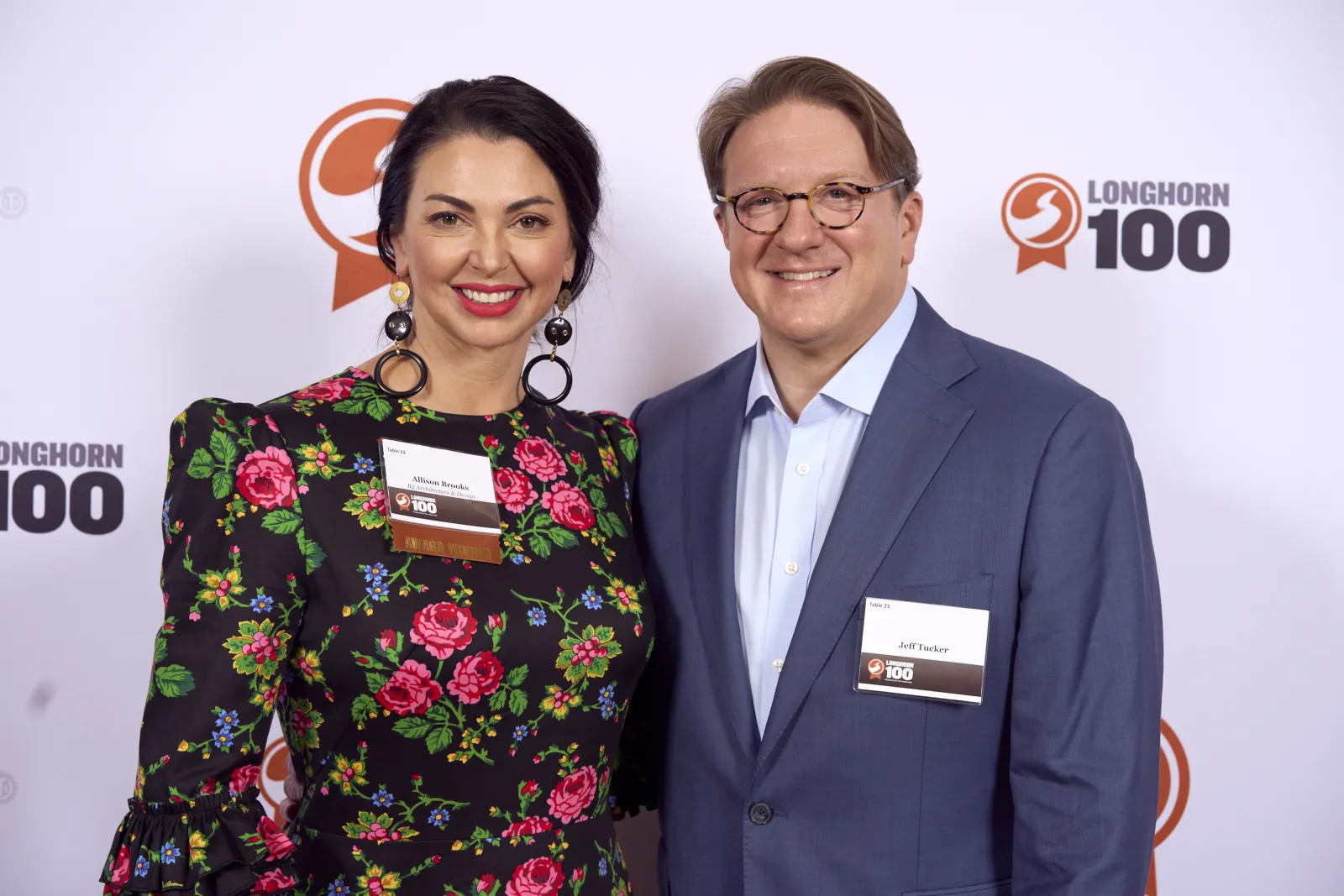 Allison Brooks and her husband in front of the Longhorn 100 step and repeat