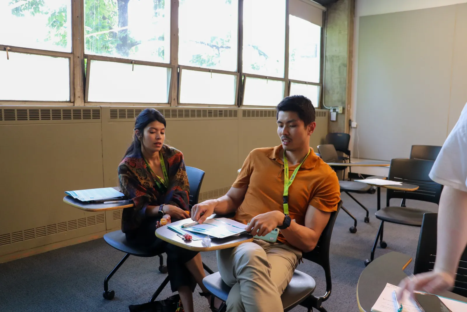 Students sitting at desks in a classroom engaging with one another