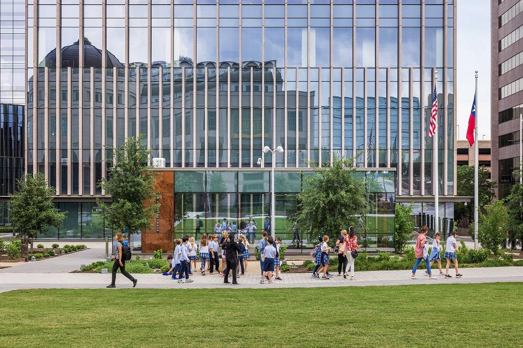 Elementary-aged students gather in front of the facade of a building on the Capitol Mall. 