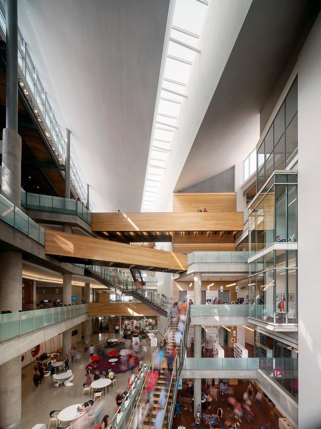 Interior shot of the Austin Central Library lobby space with people on the stairs and milling about in the lobby