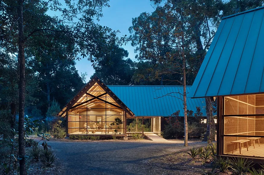 External view of the Marine Education Center at The Gulf Coast Research Laboratory (GCRL) looking into one of the spaces at dusk.