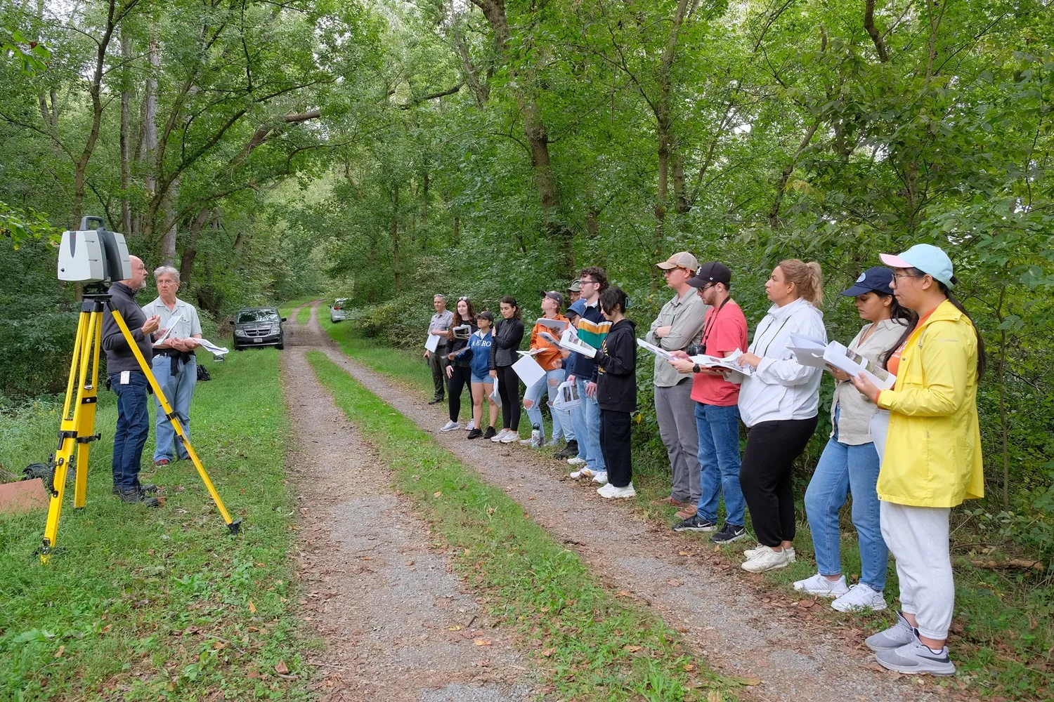 Students standing in a row listening to someone talking about LiDAR scanning