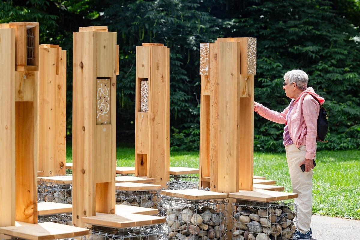 A person interacts with the Pollinator Lounge habitats