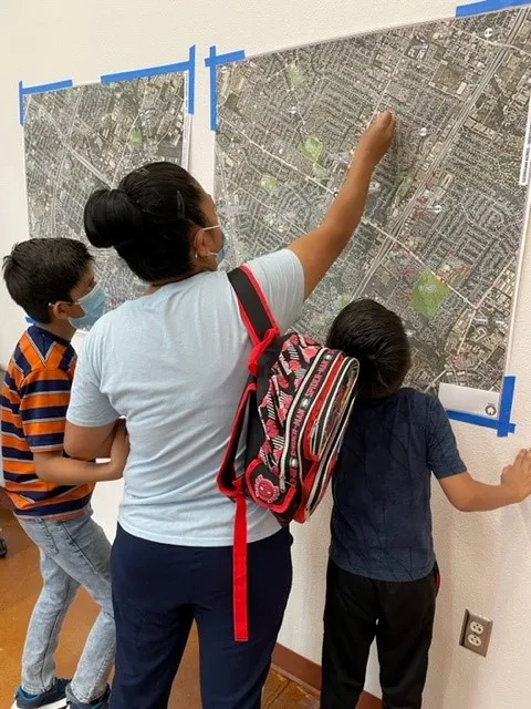 adult and two children studying a map