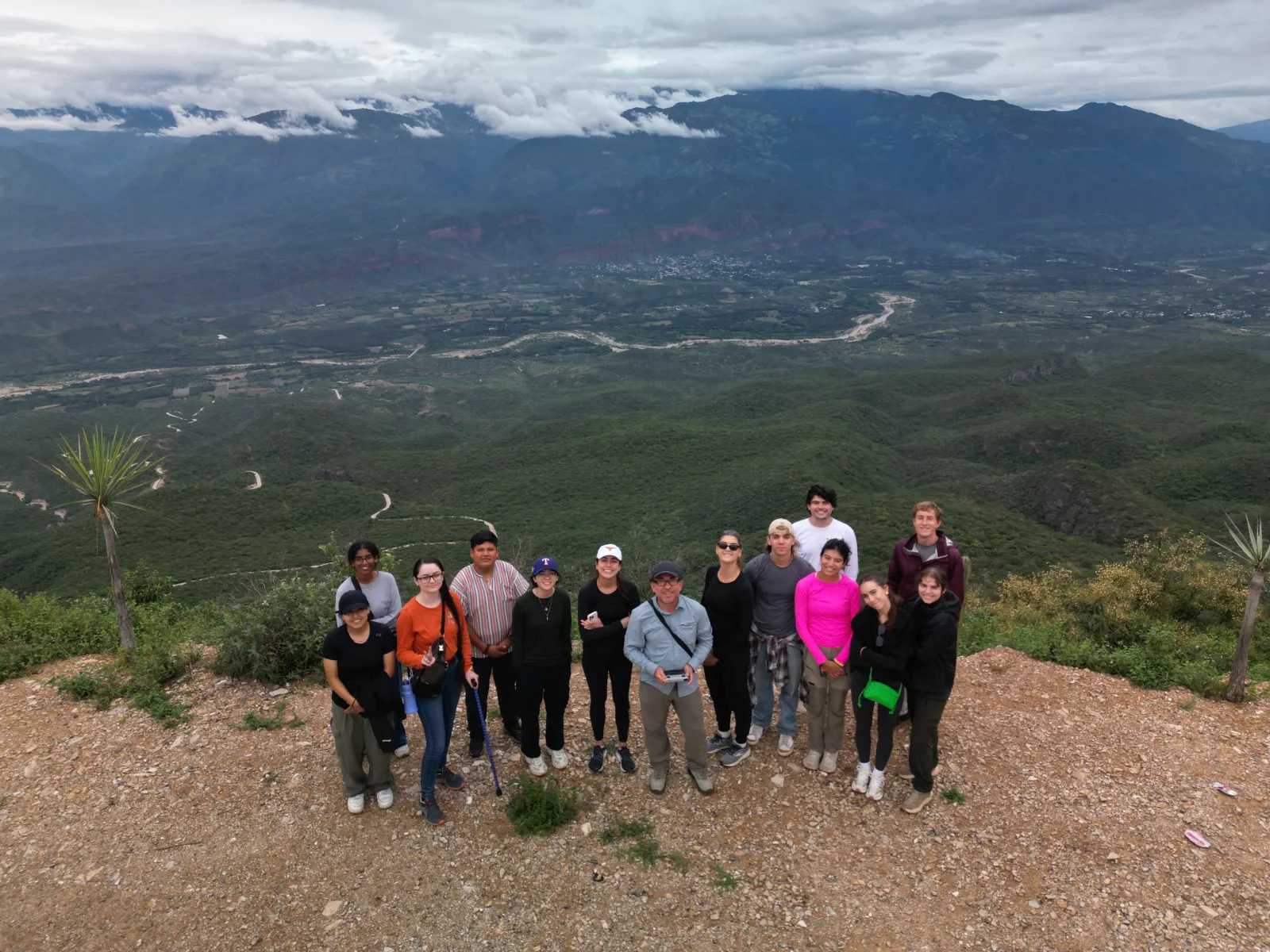 Students pose in front of vast landscape with river and mountains