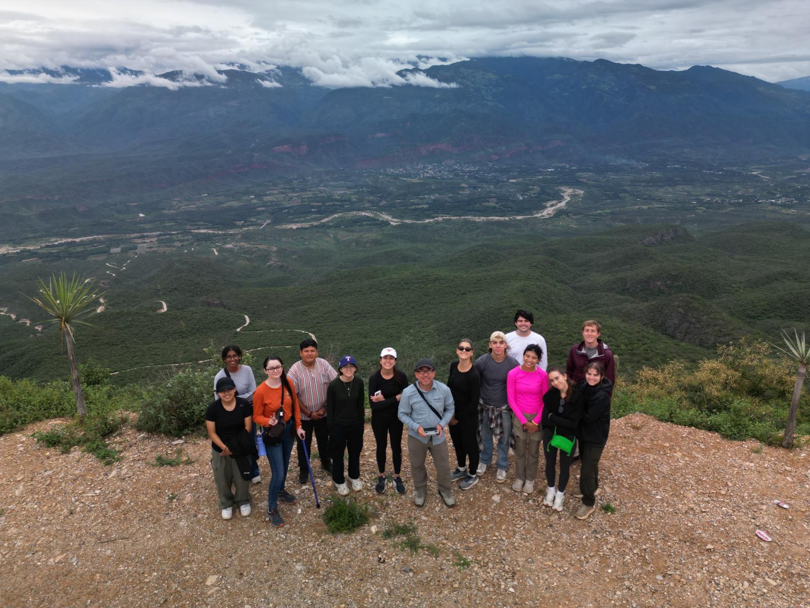 Students pose in front of vast landscape with river and mountains