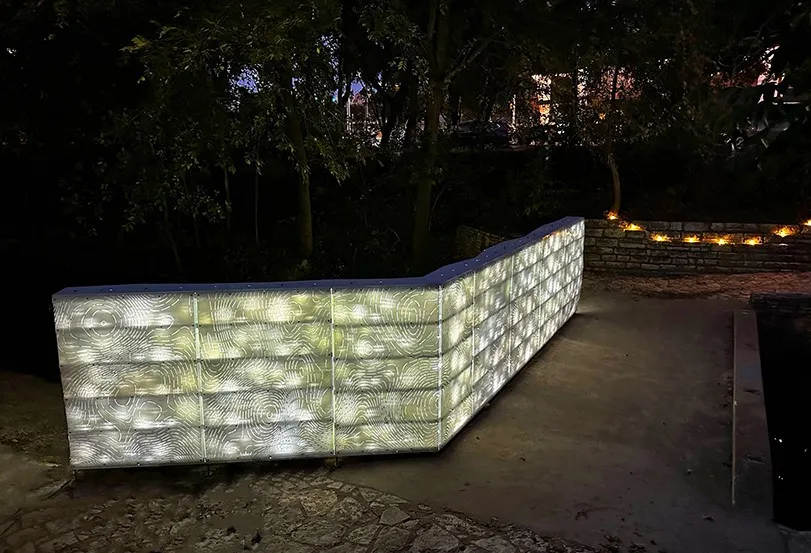 Perforated steel art installation lit up at night