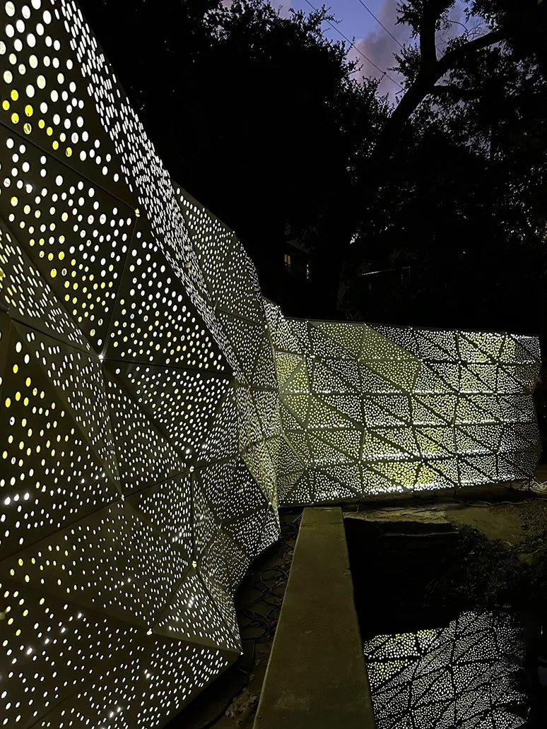 Large perforated steel structure with light shining through