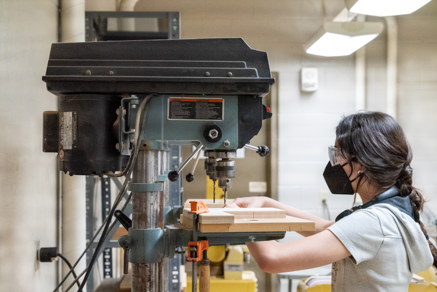 A student wearing a mask using tools in the Build Lab