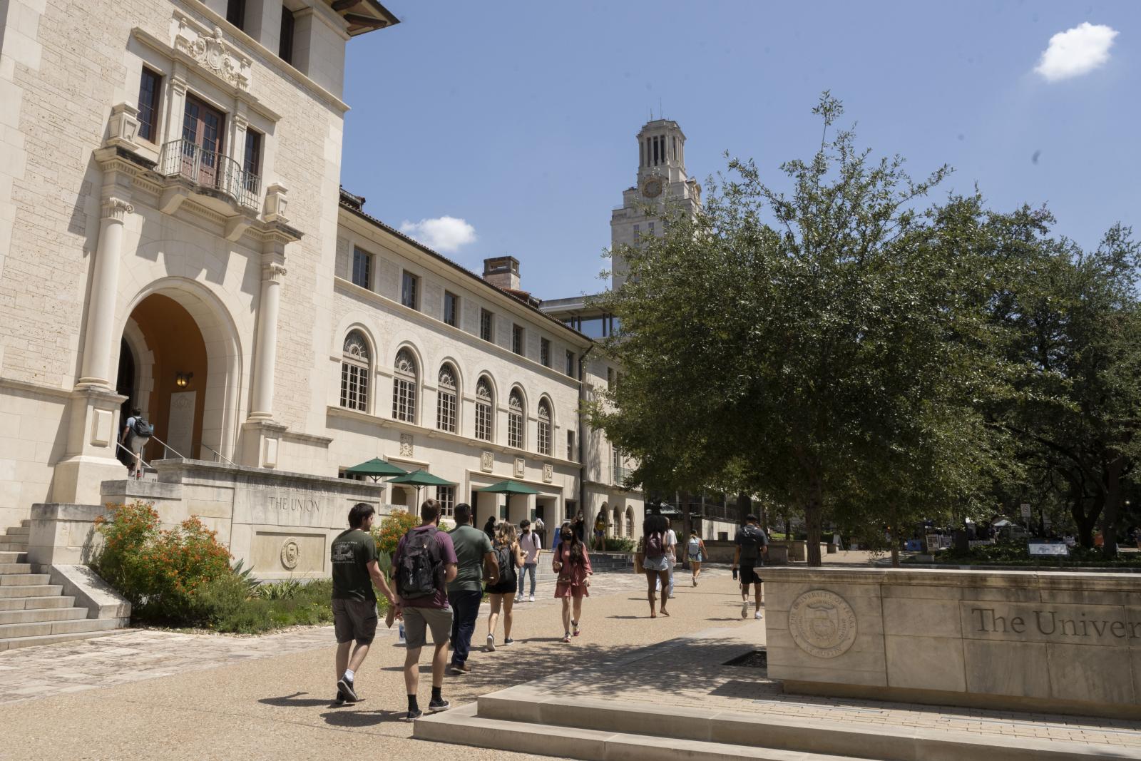 Students walk by the University of Texas at Austin Tower and Texas Union