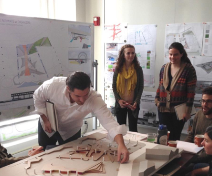 students examining an architecture model on a table 