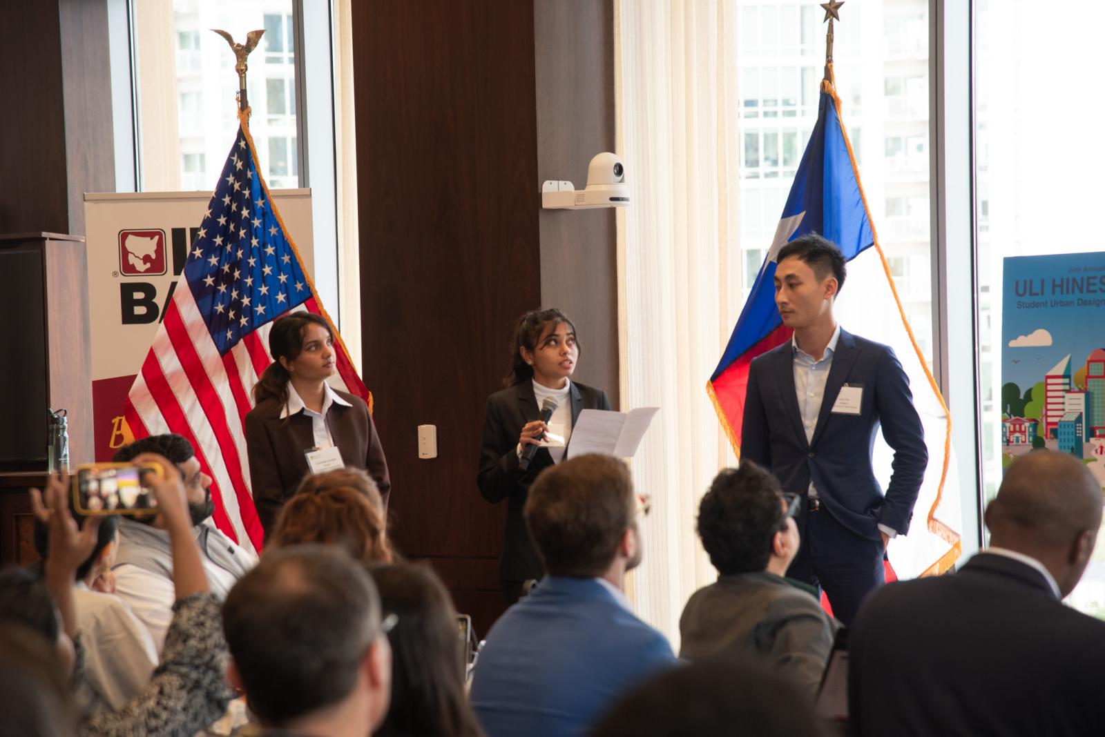 three students giving a presentation