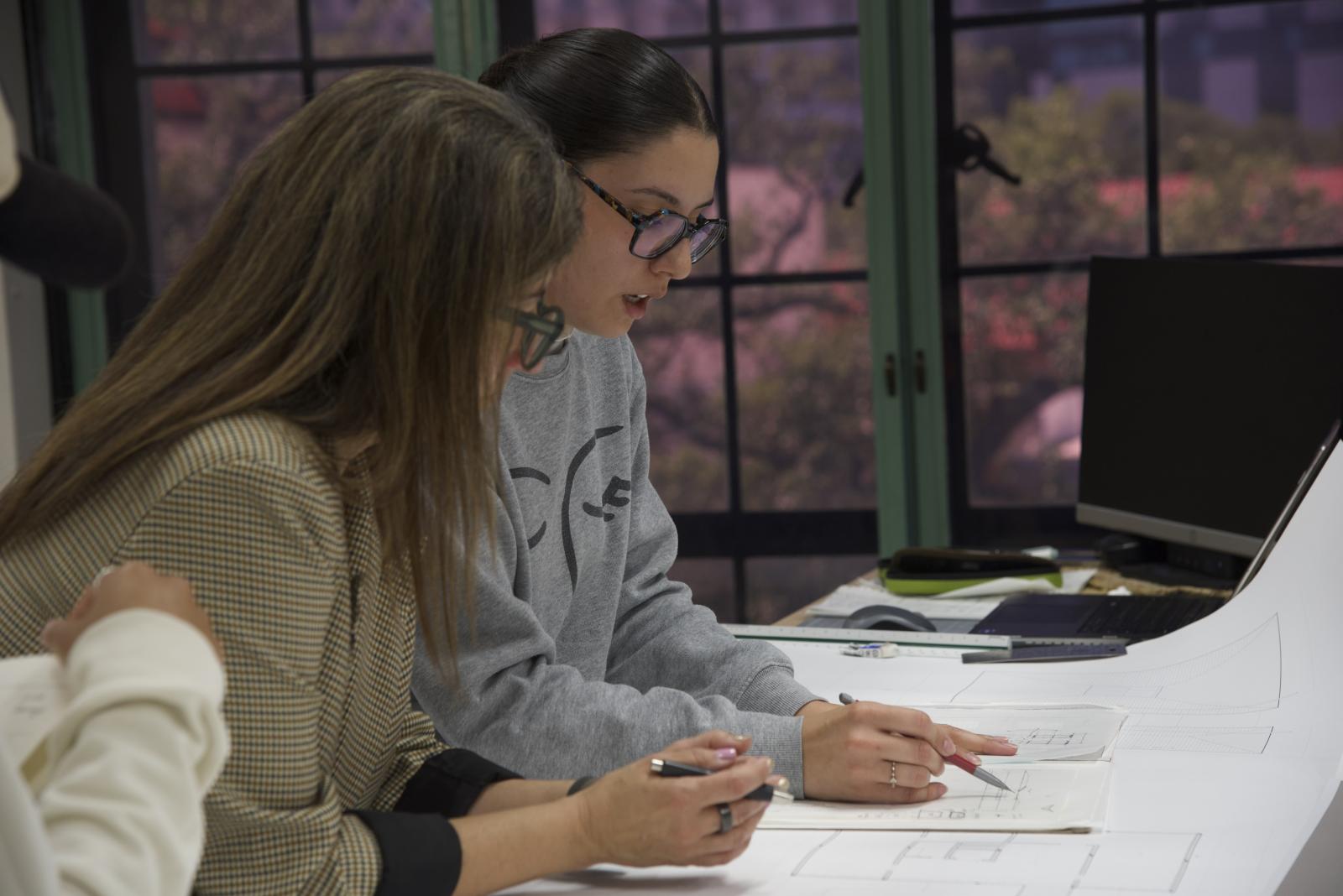 Photo from studio with a student and teacher reviewing work