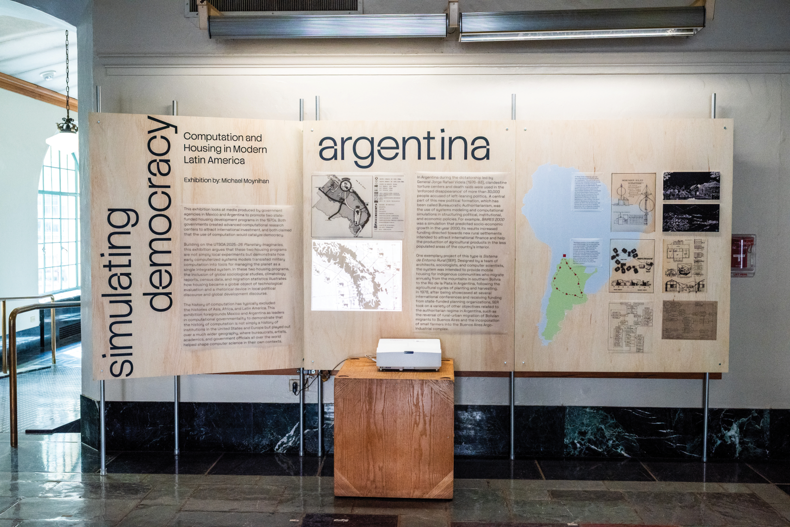 Exhibition "Simulating Democracy" on plywood boards with projector