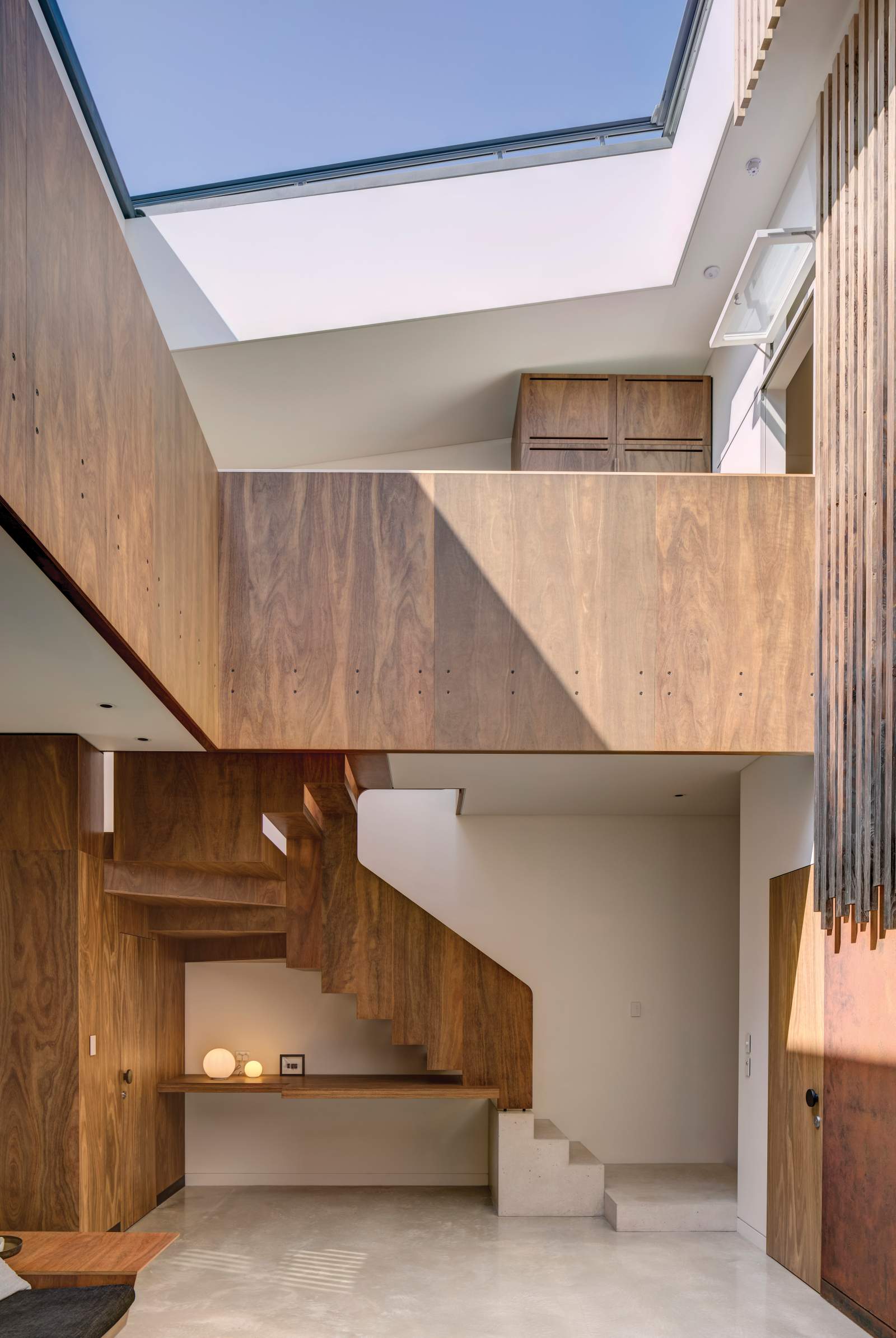 An interior view of a contemporary home with large skylight and wood paneling on the walls