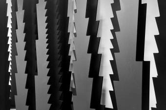 Black and white materials hang from off screen, featuring jagged edges that look like an upside down fir tree