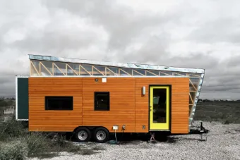 A tiny house sits in a barren landscape