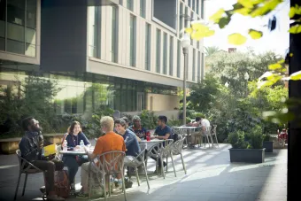 Students sitting around tables outside