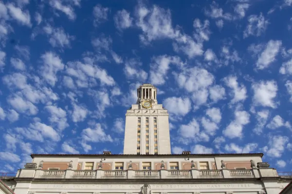 View of the UT Tower in front of bright blue skies and buttery clouds