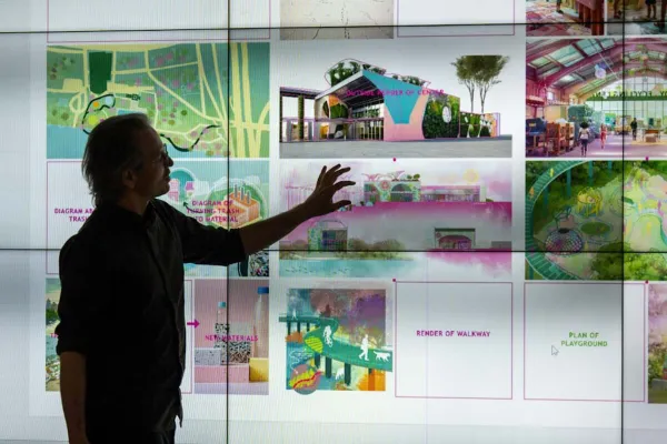 A silhouette of a person in front of digital screens.