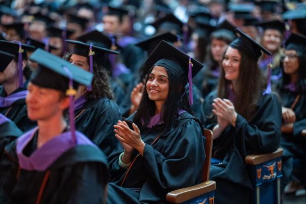 Graduates clapping at a commencement ceremony