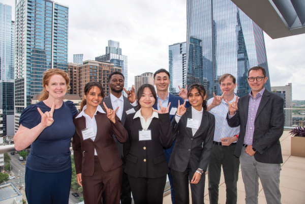 A group of students and faculty in front of the Austin city skyline