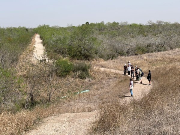 Students walk a sunny hike and bike trail in the Rio Grande Valley near Pharr Texas 