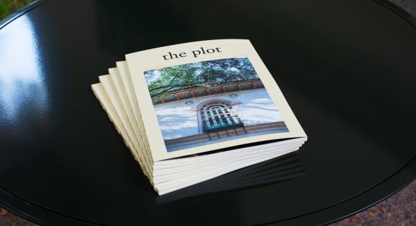 Stack of publications entitled The Plot on a table