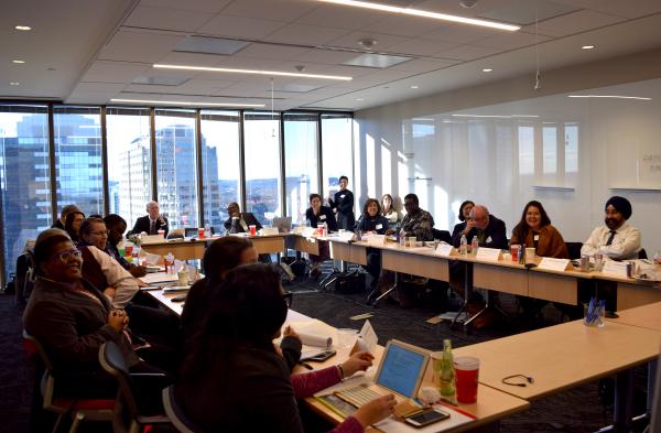 Mayors and CSD team meet at tables in board room overlooking downtown Austin