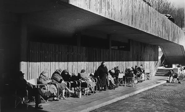 Black and white historic image of elderly residents sitting in front of a nursing home. Representing research from Willa Granger's dissertation.