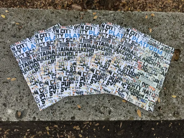 Multiple copies of PLATFORM 2020-21 laid out artfully atop a concrete bench on UT Austin's campus