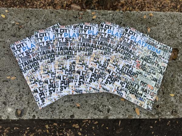 Multiple copies of PLATFORM 2020-21 laid out artfully atop a concrete bench on UT Austin's campus