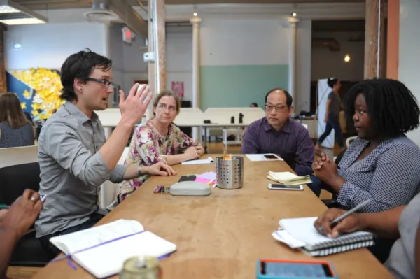 Alex Karner spiritedly speaking to a table of academics