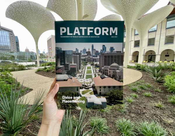 2023-2024 issue of Platform held up in the garden outside the Blanton Museum of Art looking out towards the Texas State Capitol