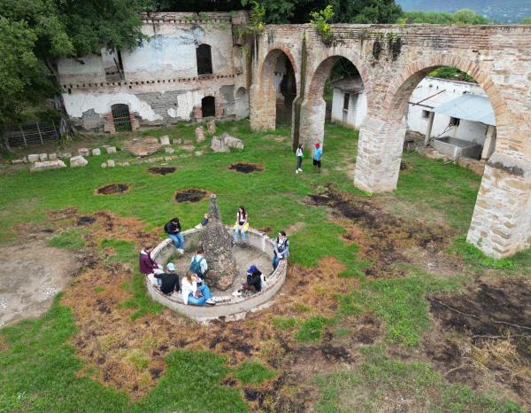 Students sit in an old fountain at a UNESCO site in Oaxaca, Mexico