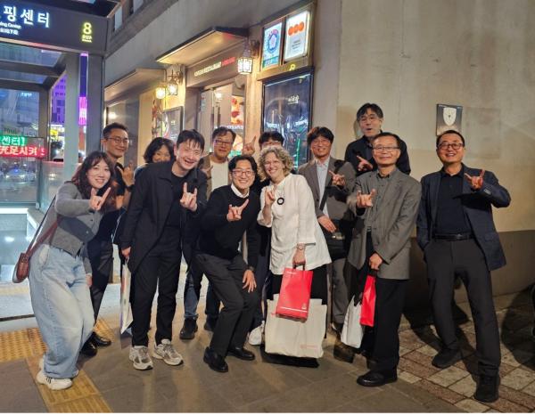 A group of people pose holding up hook em horns hand sign